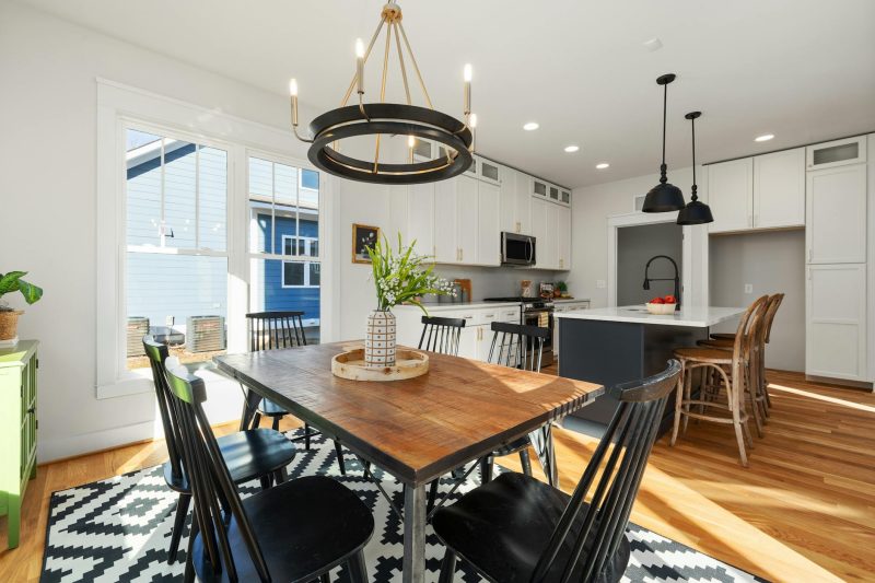 Bright, modern kitchen with stylish furnishings, a dining table, and abundant natural light streaming in.