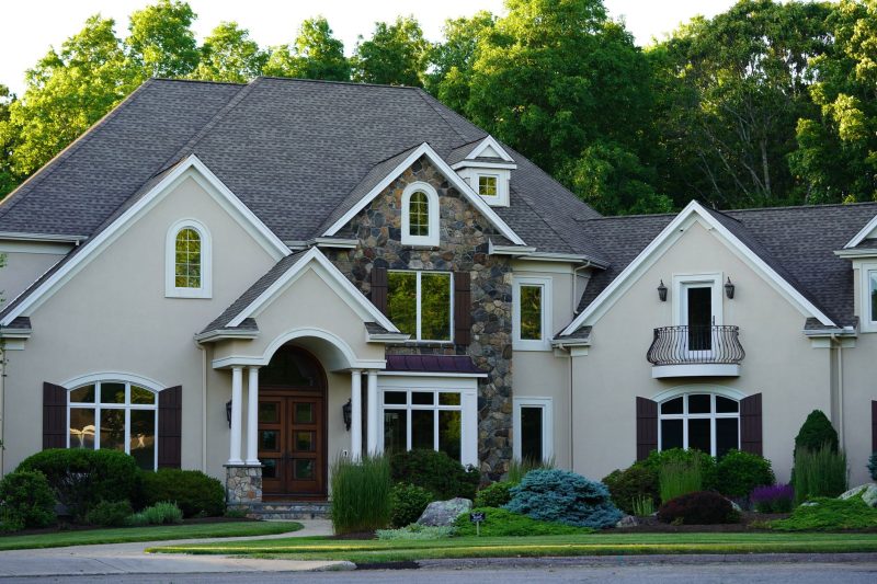 A large suburban house nestled among lush greenery in a tranquil neighborhood setting.