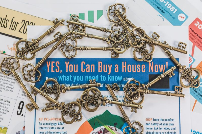 Vintage keys scattered atop real estate documents, symbolizing property ownership and investment.